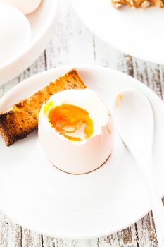 The soft-boiled egg in an eggcup with toasted bread