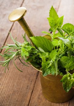 Fresh herbs in the copper mortar on the table