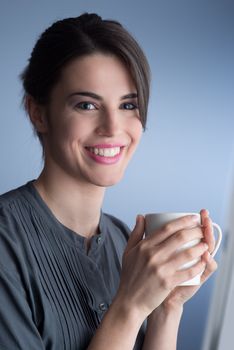 Beautiful woman smiling and holding a cup of coffee.