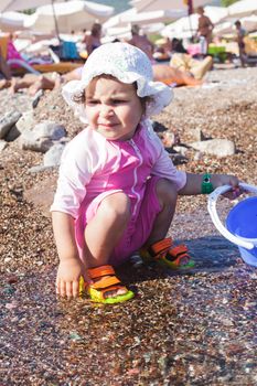 Baby play on seashore with sea water