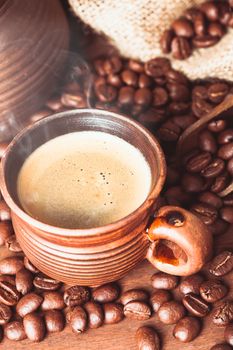 Cup of coffee over spilled beans on the table