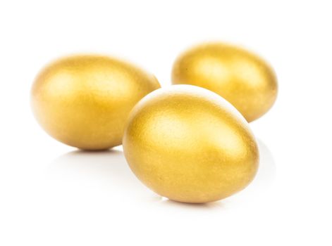 Three golden eggs isolated on white background
