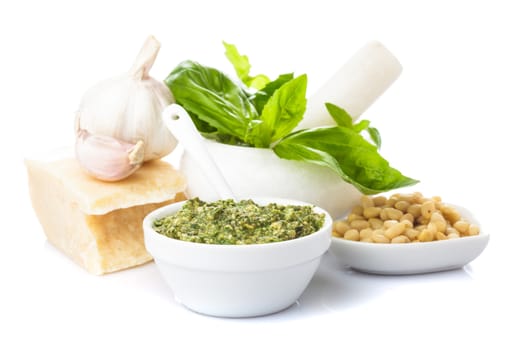 Pesto sauce ingredients: fresh green basil, parmesan, pine nuts and garlic. On white