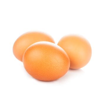 Three beige chicken eggs isolated on white