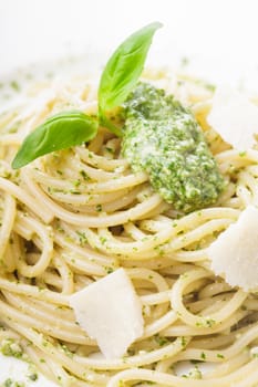 Spaghetti with green pesto and parmesan on the plate