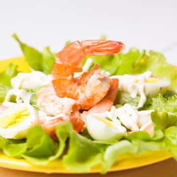 Salad with boiled shrimps, quail eggs and sauce