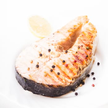 Salmon grilled steak with peppercorn and lemon close up