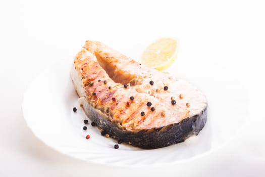 Salmon grilled steak with peppercorn and lemon close up