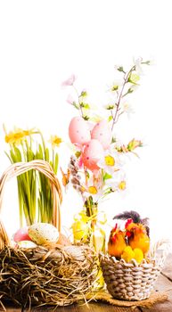 Pink and yellow eggs in basket, Easter decorations on white background