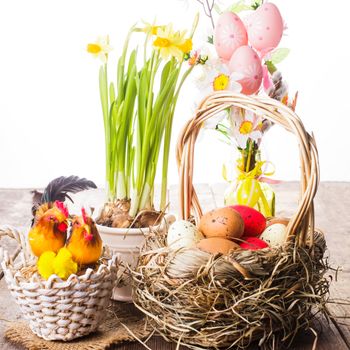 Pink and yellow eggs in basket, Easter decorations on white background