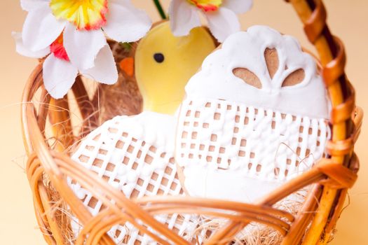 Easter cookies in basket over yellow background. Easter decor