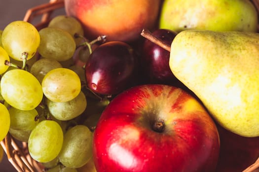 Autumnal fruits in the basket as a background