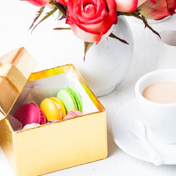 macaroons in gift box and roses in vase