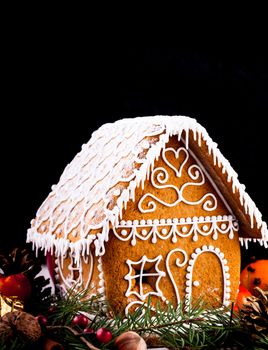 gingerbread house with christmas decorations on a black backgrond