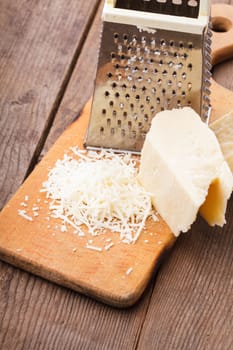 Grated Parmesan cheese with grater on a table