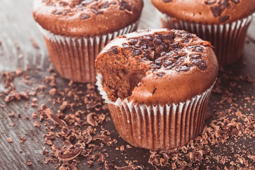 Chocolate muffins with chocolate chips on the wood background closeup
