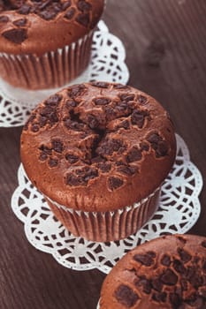 Chocolate muffins with chocolate chips on the wood background closeup