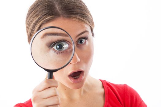 Girl looking through a magnifying glass and being surprised, isolated on white