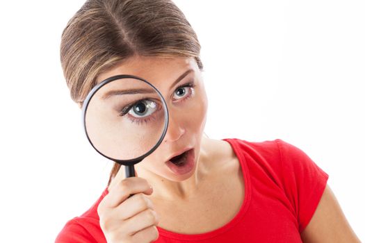 Girl looking through a magnifying glass and looking surprised, isolated on white