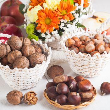 Hazelnuts, walnuts and chesnuts with apples and autumnal bouquet