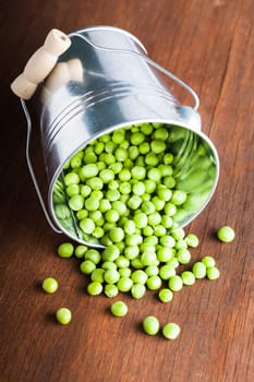 Green pea scattered on the wooden table