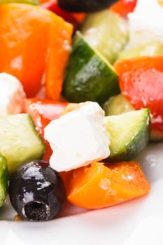 Greek salad with feta cheese macro on white plate