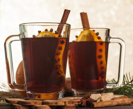 A mulled wine in the glass cup on wooden background