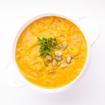 Pumpkin soup in white bowl on the white background