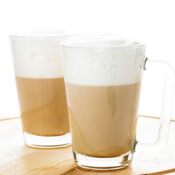 Coffee latte in glass mugs on the board