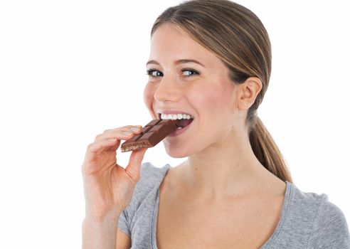 Portrait of a young woman biting in a chocolate tablet, isolated on white