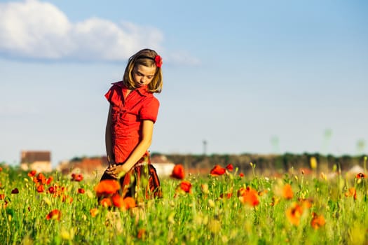 Girl stand with arms outstretched in the poppies field and enjoy the nature