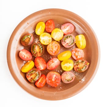 Various types of cherry tomatoes on the plate, isolated on white