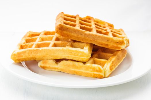 Three waffles on a white plate closeup