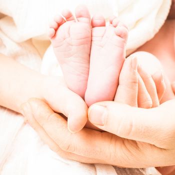 Baby foots in mother and father hands