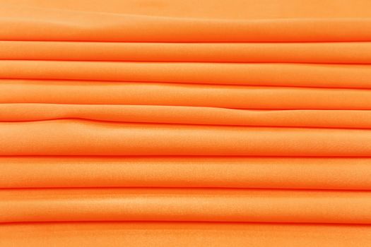 Folded orange silk. To be used as background.