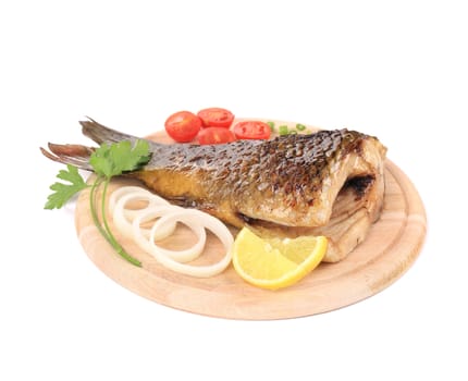 Fried carp tail with lemon and cherry tomatoes. On a white background.