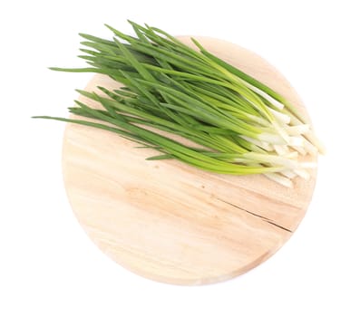 Bunch of green onion on wooden platter. Isolated on a white background.