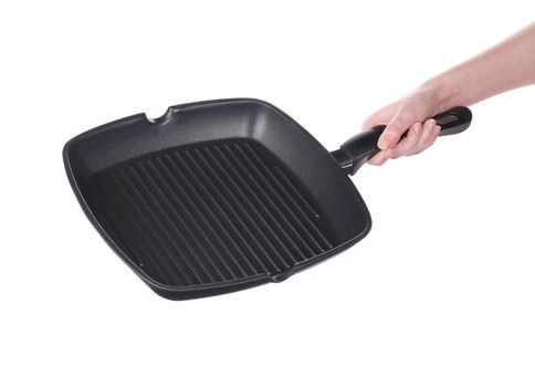 Hand holds a black frying grill pan. Isolated on a white background