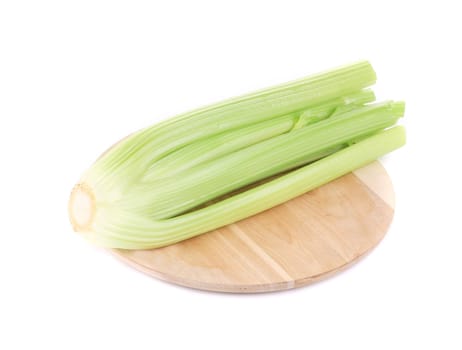 close up of fresh celery  on wooden platter. Isolated on a white background
