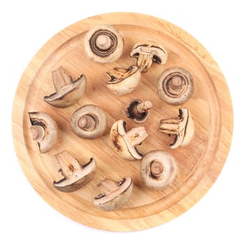 Mushrooms on wooden platter. Isolated on white background.