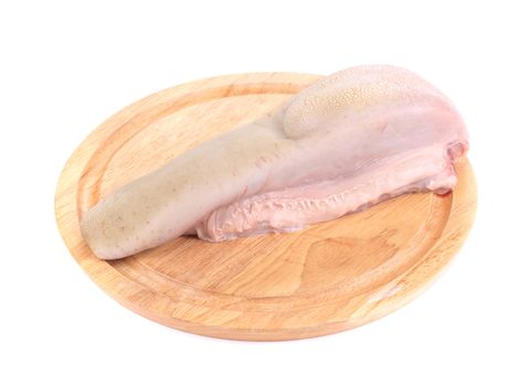 Raw cow tongue on wooden platter. Isolated on a white background.