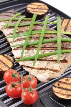 Grilled carp fillet on grill with egg plant. Whole background.