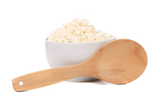Cottage cheese in bowl with spoon. Isolated on a white background.