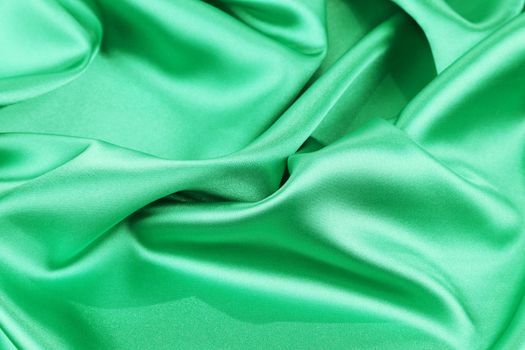 Green silk background soft folds and highlights. Whole background.