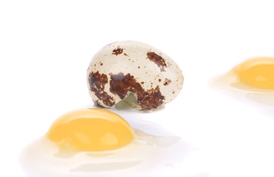 Close up of raw broken quail eggs. Isolated on a white background.