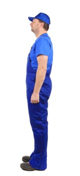 Worker in blue overalls. Side view. Isolated on a white background.