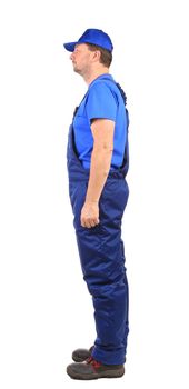 Worker in blue overalls. Side view. Isolated on a white background.