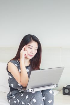 Young woman playing internet on tablet and thinking