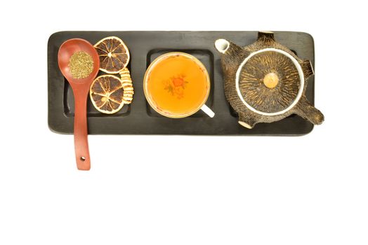 teapot wooden spoon and dried orange on wooden tray isolated on white background