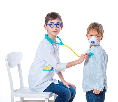 Portrait of a little smiling doctor with stethoscope and syringe with his patient. Isolated on white background
